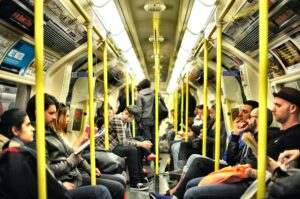 Photo of people seated and standing in an underground train