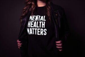 A person wearing a black top that says mental health matters