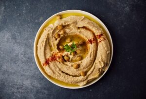 A bowl of hummus with chickpeas on top