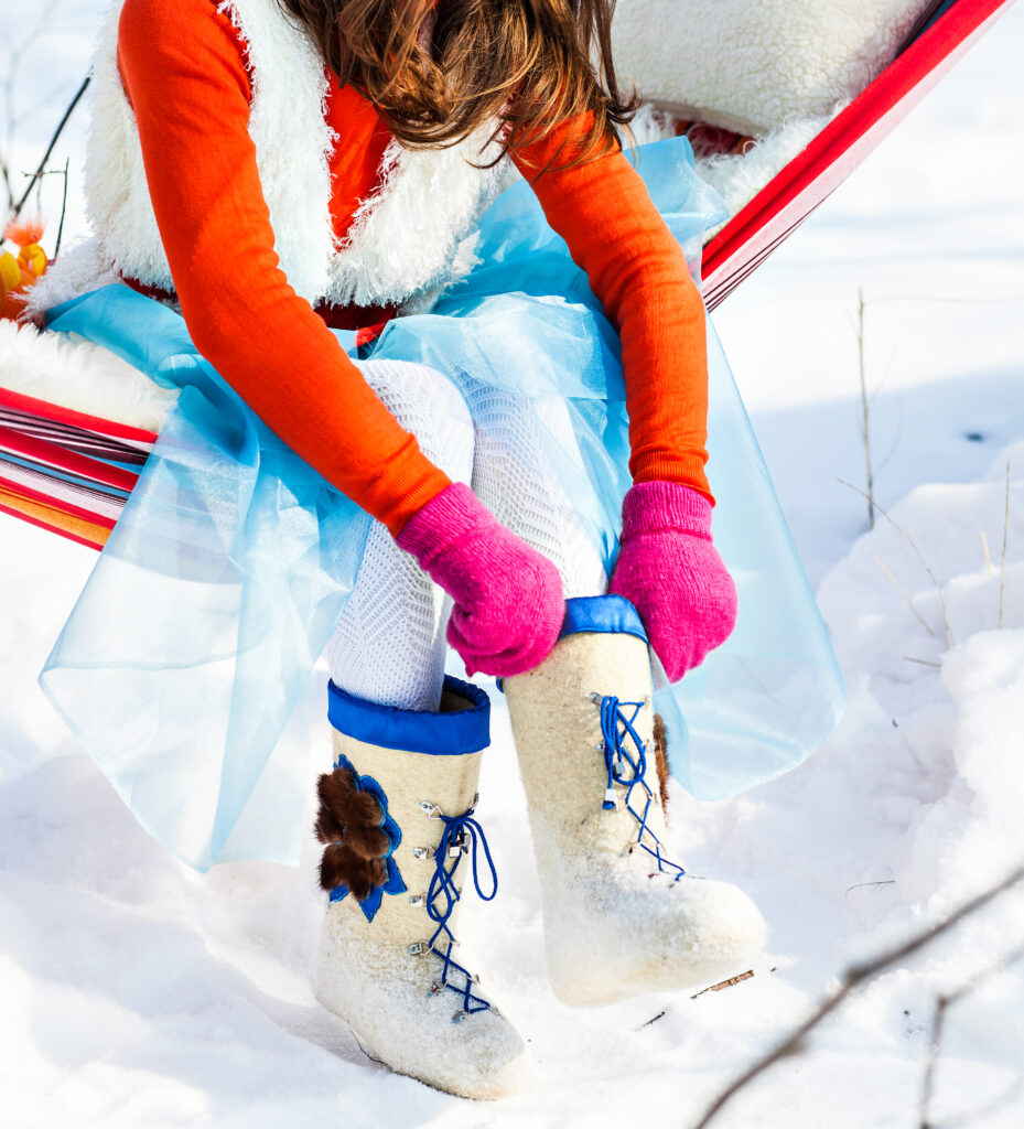 Woman put on her winter shoes. felt boots.