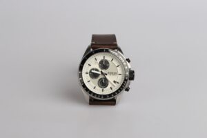 A picture of a brown watch in front of a white background