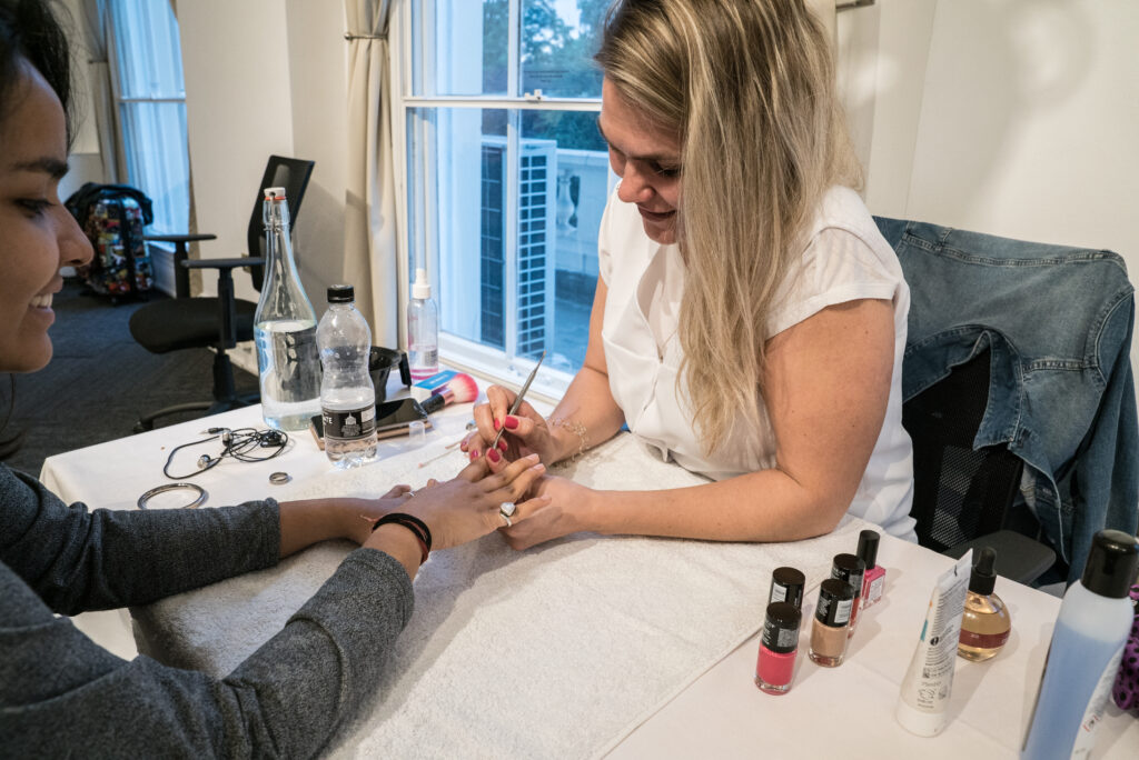 A women painting another women's nails