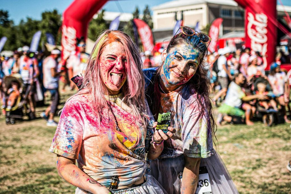 Two people smiling at the camera with paint on their faces 